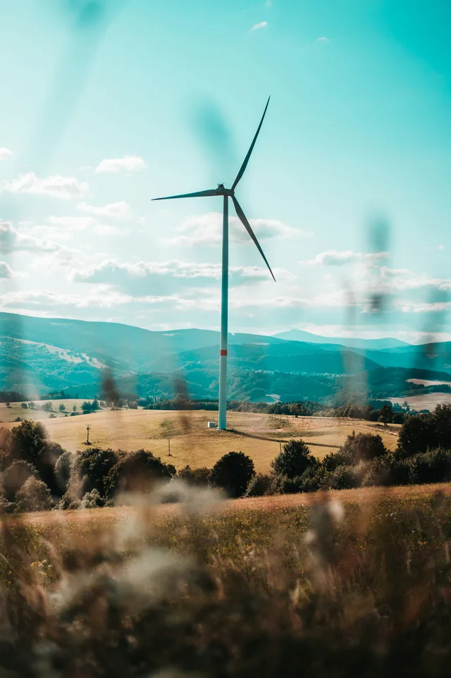 Turbina eólica se erguendo sob um céu azul e limpo
